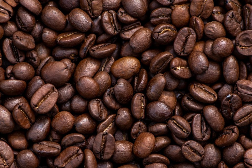 Geröstete Kaffeebohnen liegen ausgebreitet lückenlos von oben fotografiert